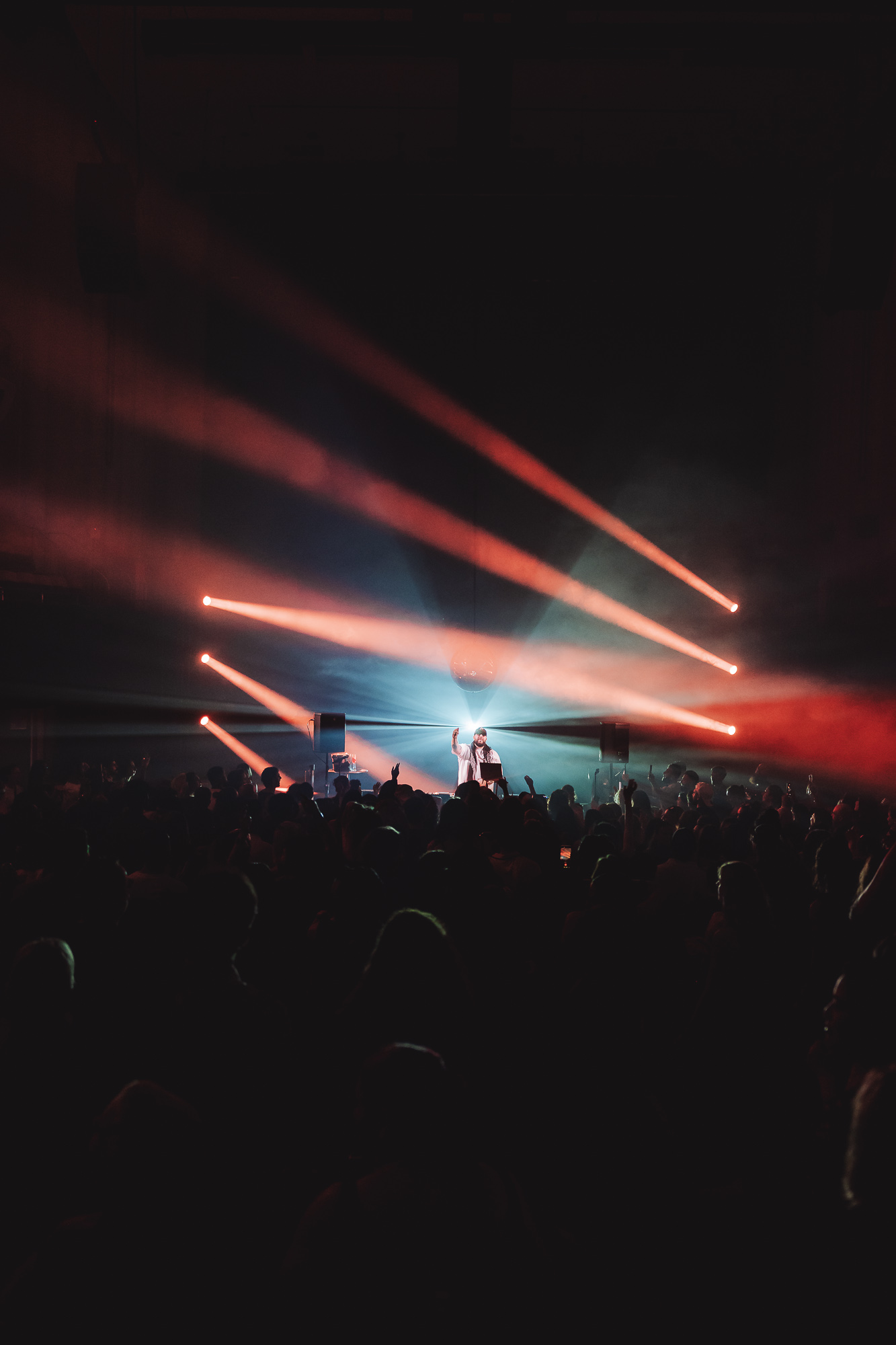 Red lasers sweeping over a concert crowd