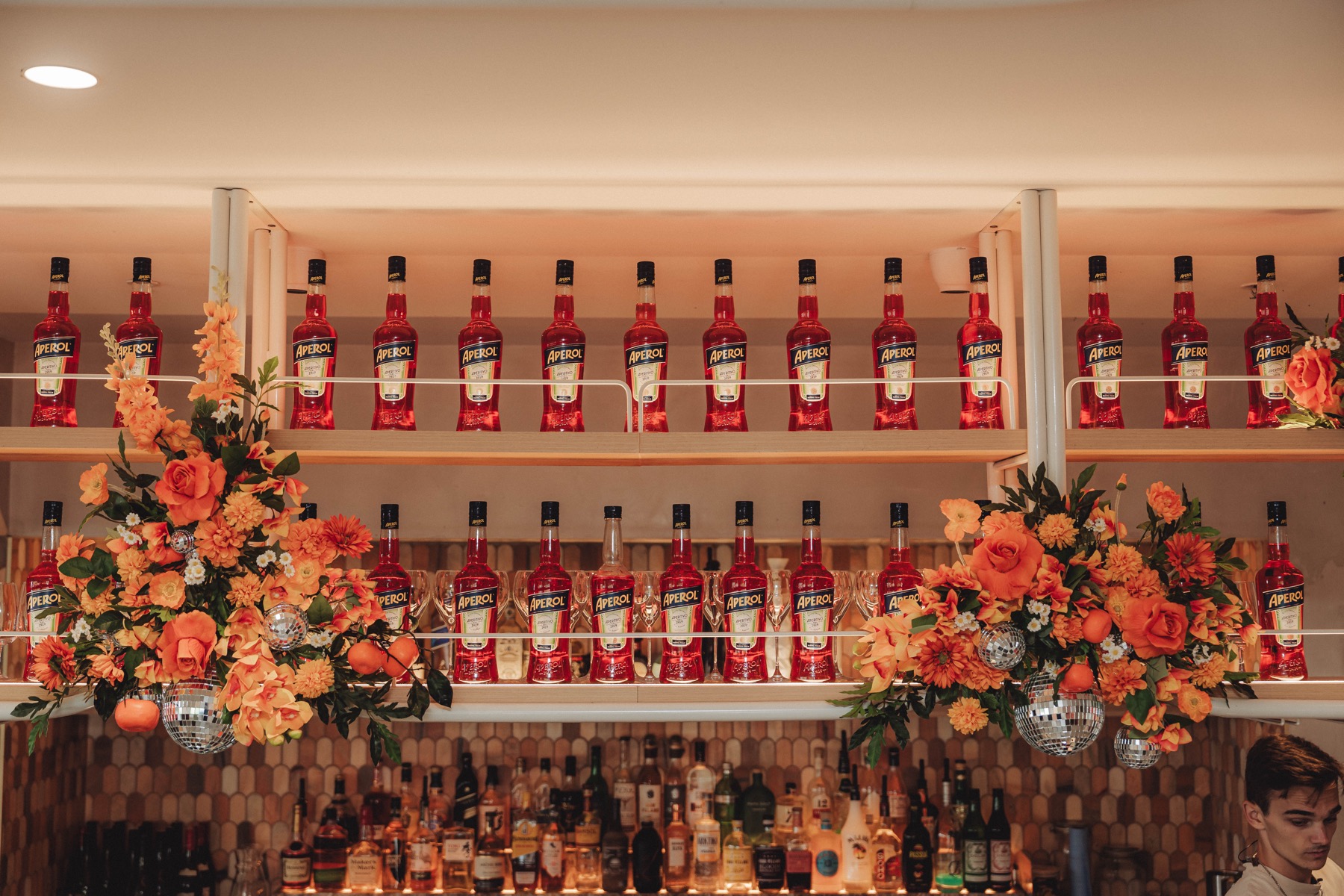 Back-bar bottle display styled with fresh flowers