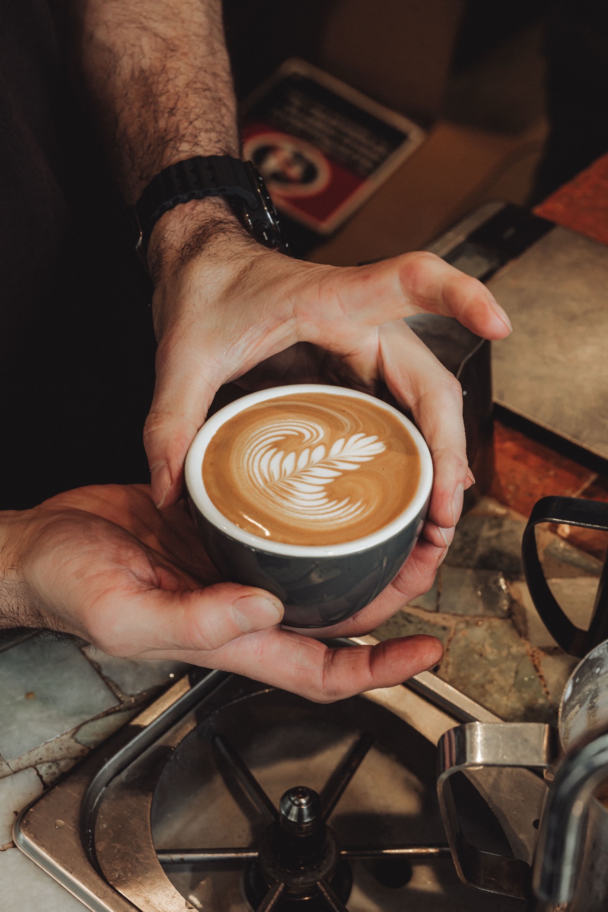 Latte art held in two hands at Stranger Espresso
