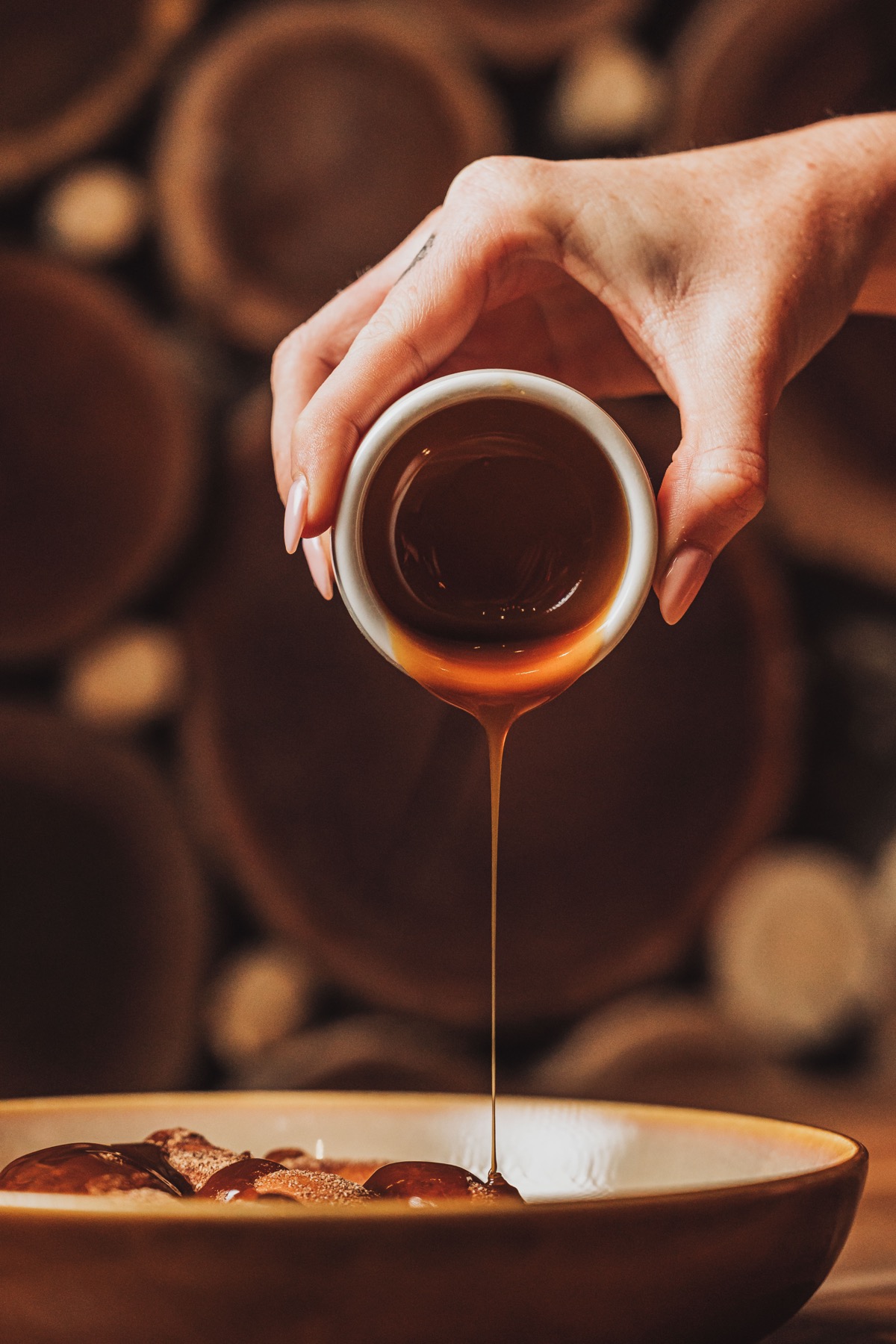 Syrup poured over a dessert in warm light