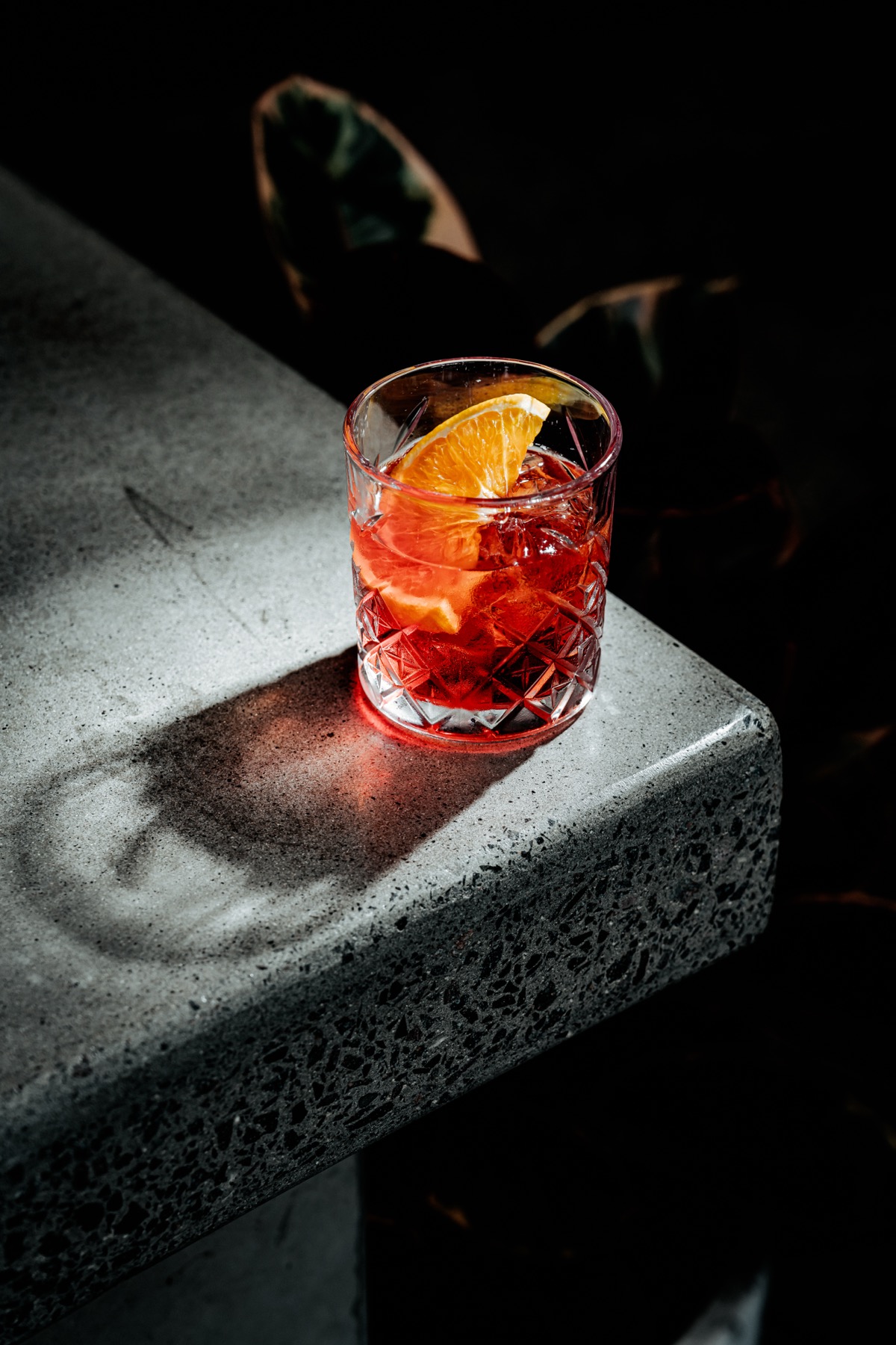 Negroni on a stone ledge in dramatic light